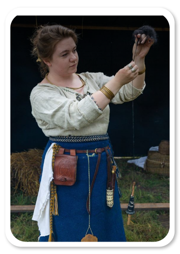 Kultūros paso edukacija „Kas mes? Nuo akmens amžiaus iki Kuršių genties“. Moteris vynioja siūlą.