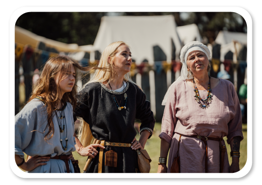 Medgrinda tarptautiniame eksperimentinės archeologijos festivalyje Gyvosios archeologijos dienos. Trys moterys vilkinčios to meto tradicinius drabužius.